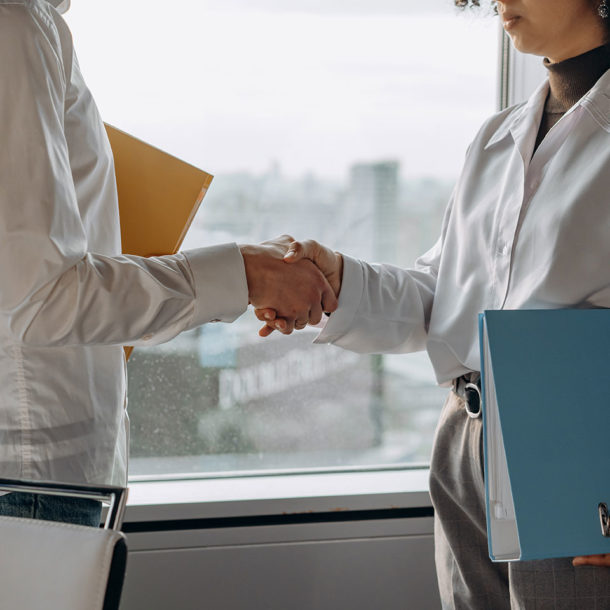 business people with document folders shaking hands