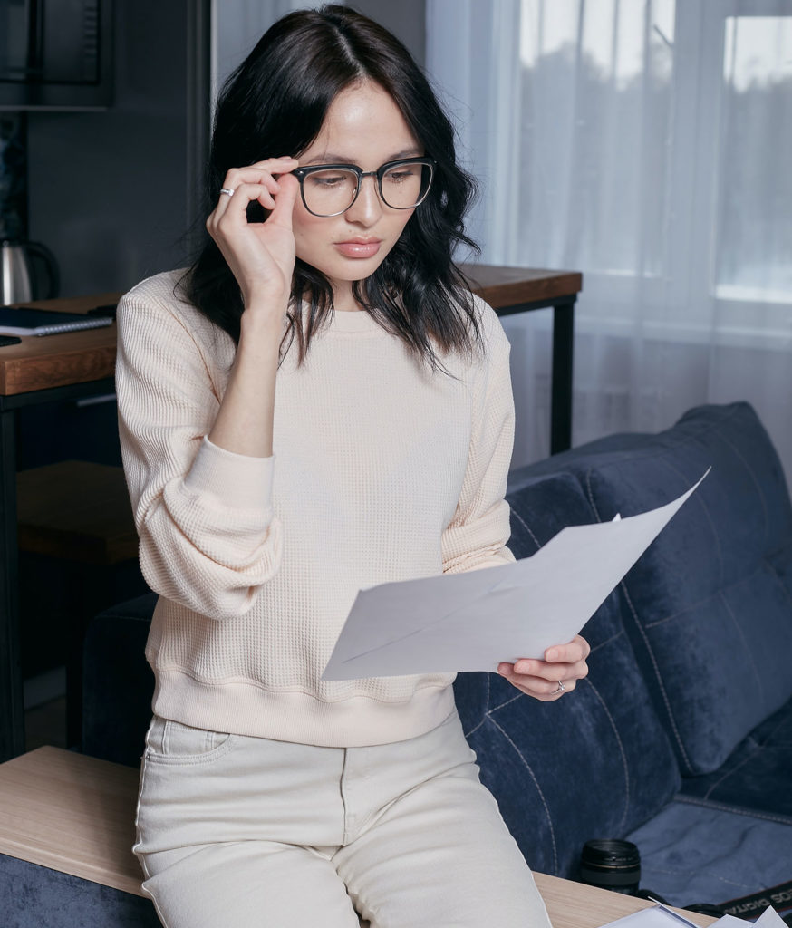fintech marketing agency girl in glasses with a sheet of paper sitting on a table in the office