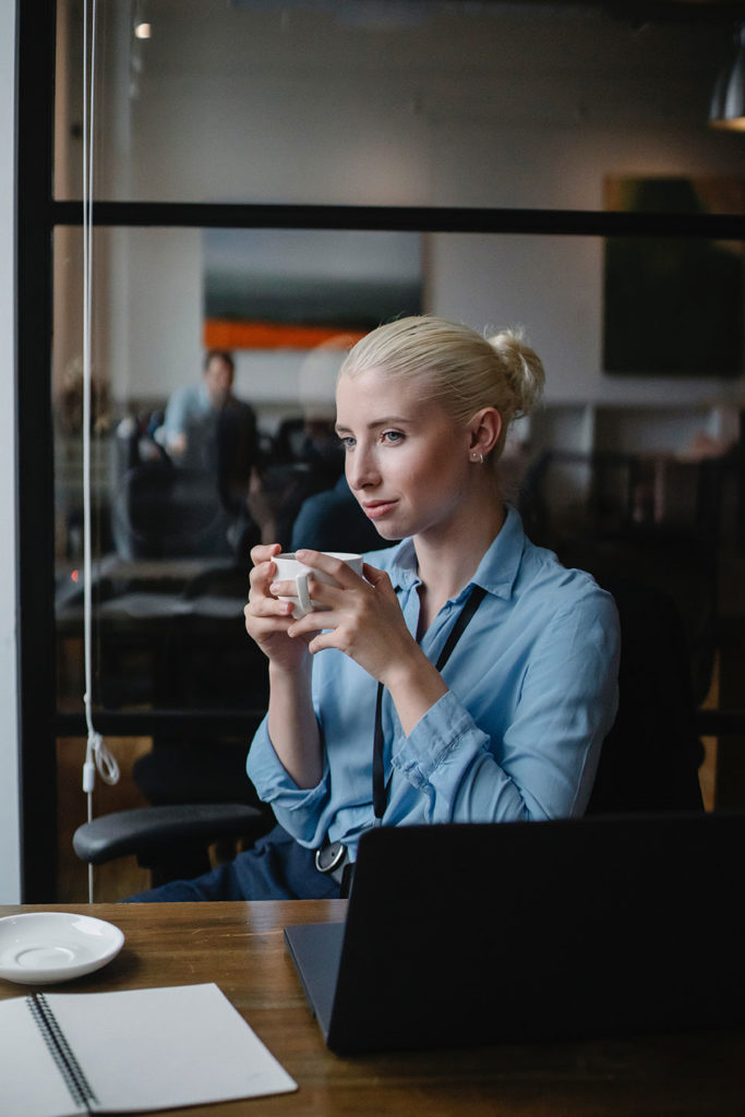 blonde girl in the office with a cup of coffee